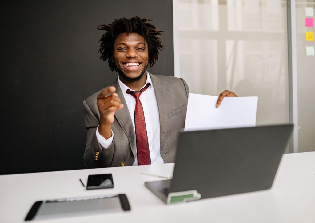 Homem sorrindo em escritório segurando papel
